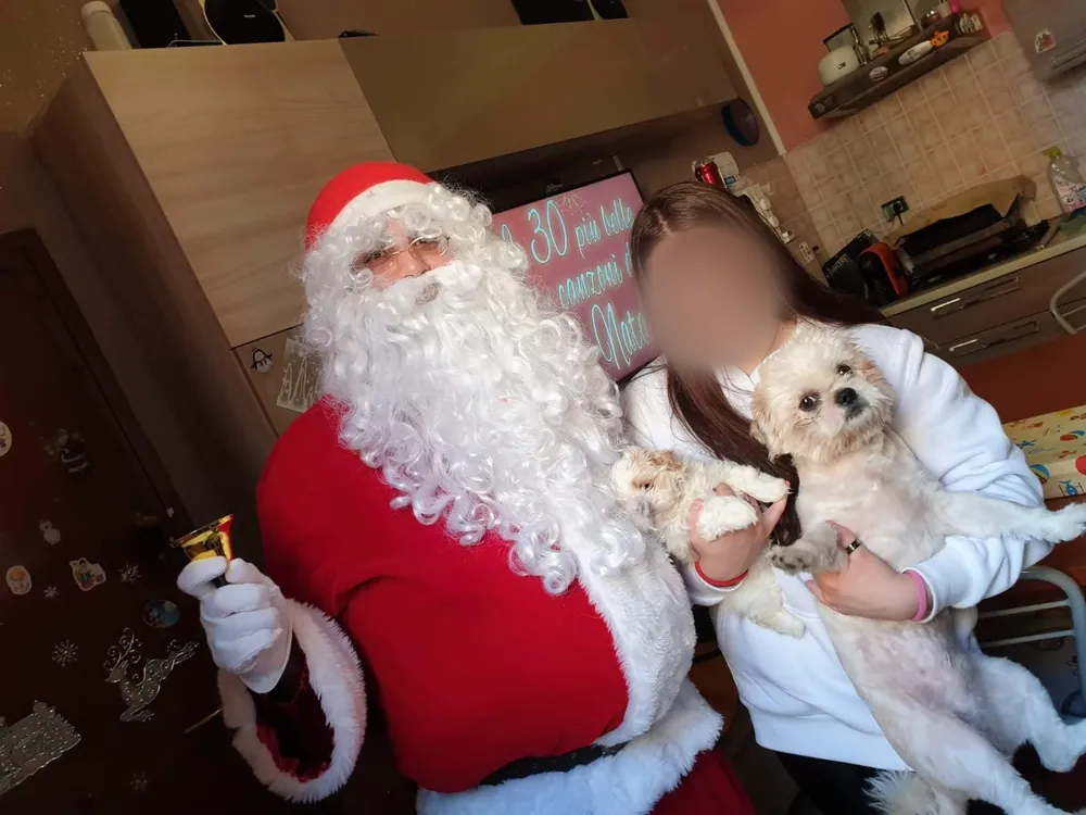 Babbo Natale in salotto con una ragazza e il suo cagnolino