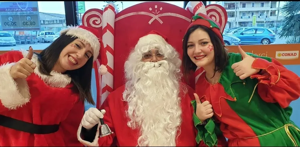 Babbo Natale con due elfe a un evento in un supermercato