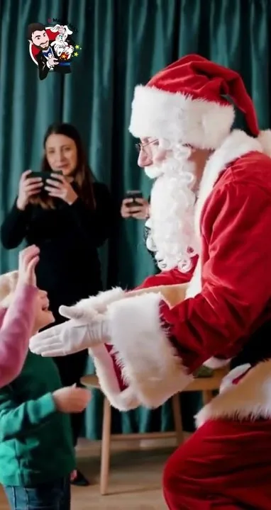 Babbo Natale a domicilio abbraccia una bambina durante la visita