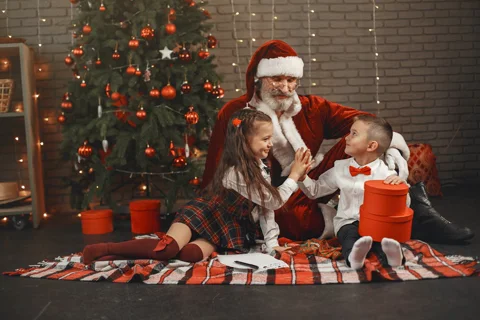 Babbo Natale con bambini davanti all'albero di Natale decorato