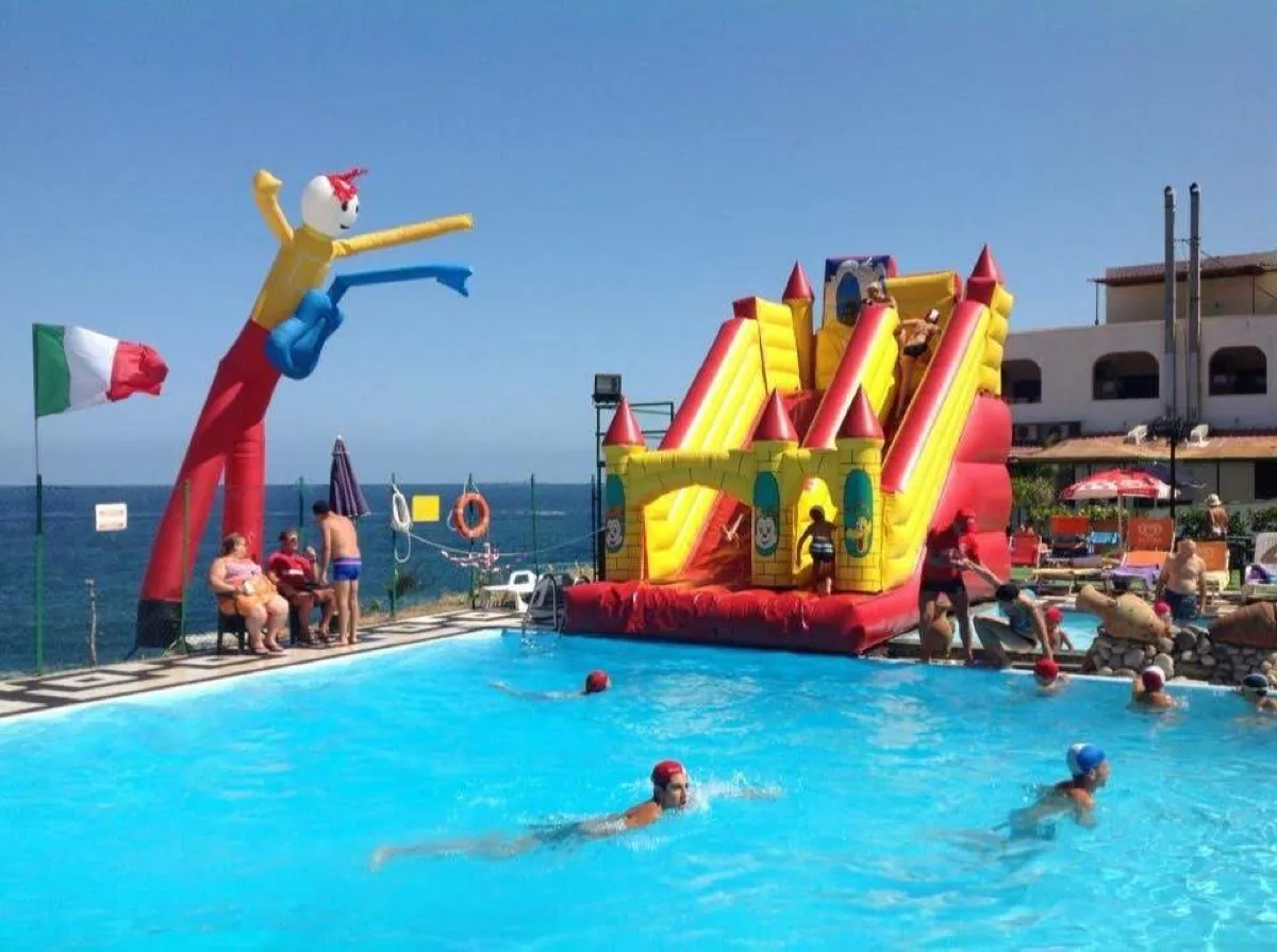 Bambini in piscina durante una festa di fine grest in Sicilia con scivolandia