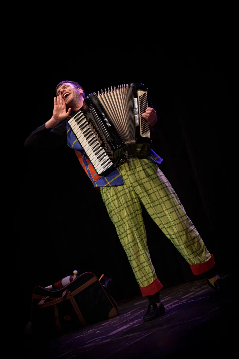 Il clown suona la fisarmonica nello spettacolo teatrale