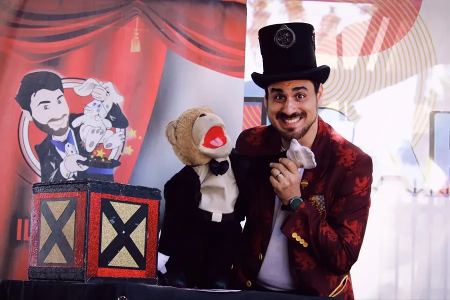 Il Mago Max con il pupazzo Tano sul palco di un evento all'aperto