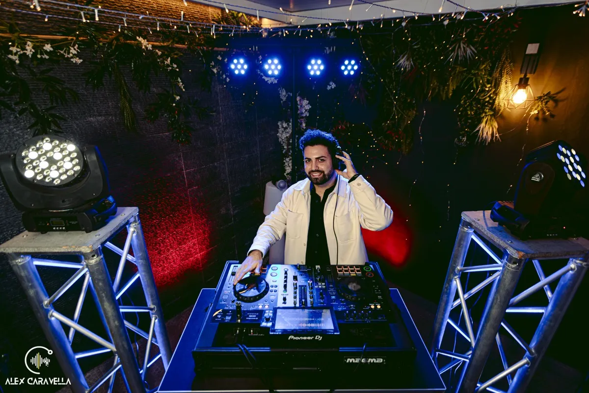 Alex Caravella alla consolle con luci blu