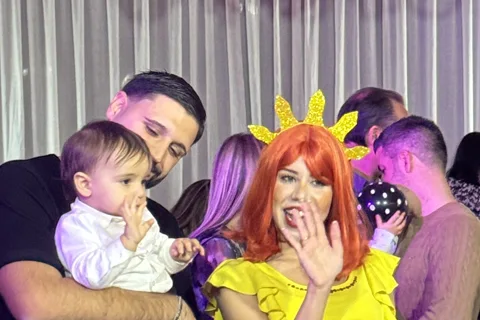 Animatrice Lucilla con parrucca arancione e Mago Max che tiene bimbo in braccio a festa