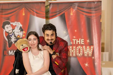 Mago Max in giacca rossa con bambina e Tano l'orsetto ventriloquo