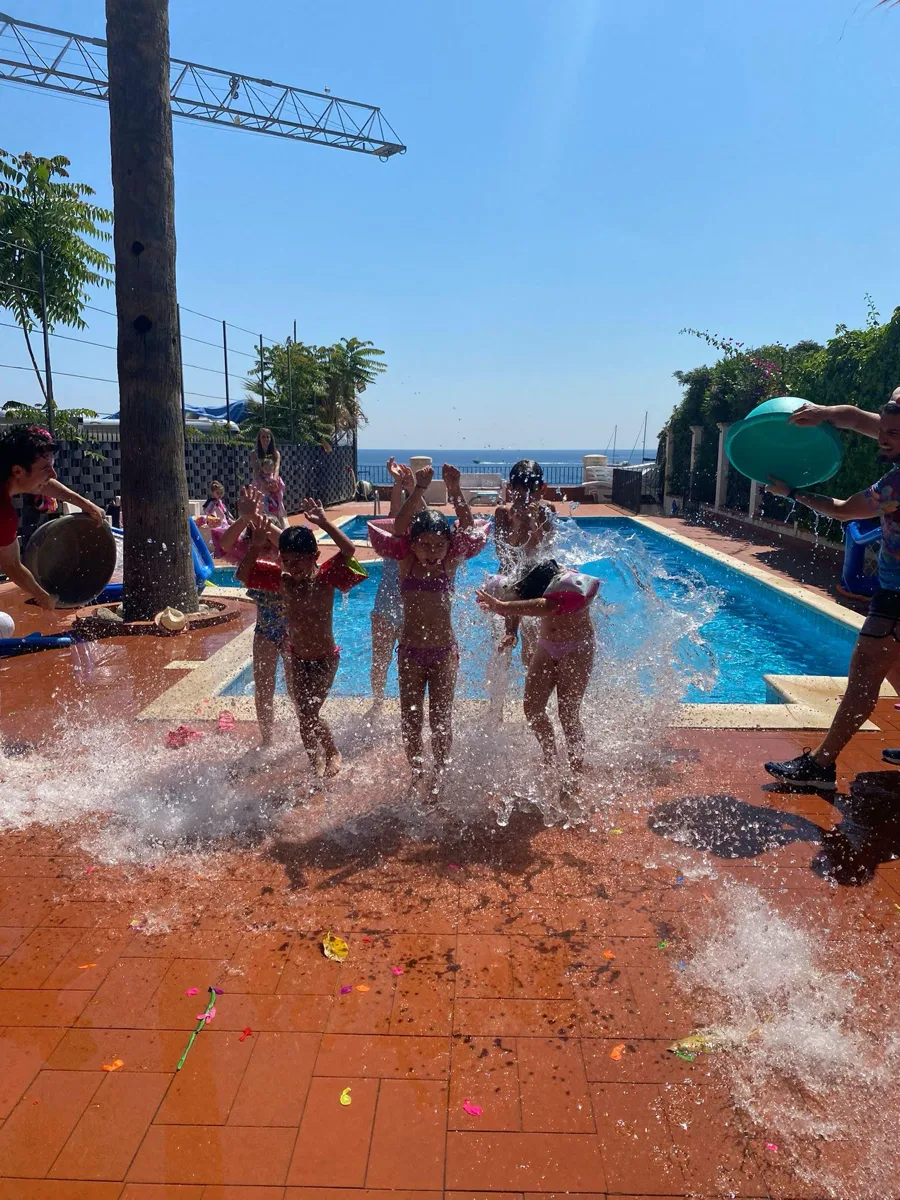 Bambini che saltano in piscina con splash d'acqua