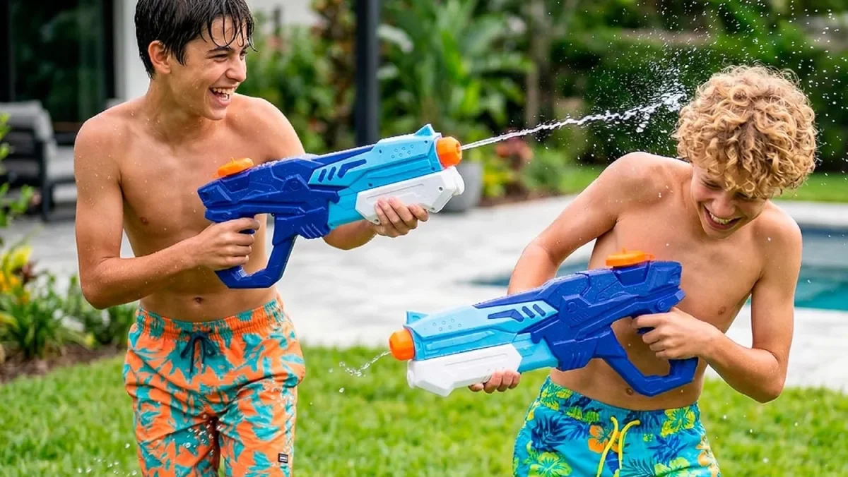 Due bambini si sfidano con le pistole ad acqua durante la festa