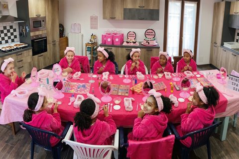 9 bambine in accappatoi rosa fucsia con fasce e maschere skincare alla festa Beauty Spa Party