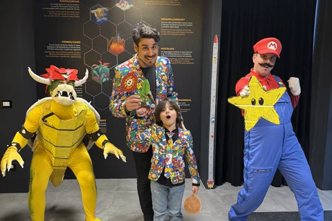 Mago Max in giacca Super Mario con bambina e mascotte Mario e Bowser