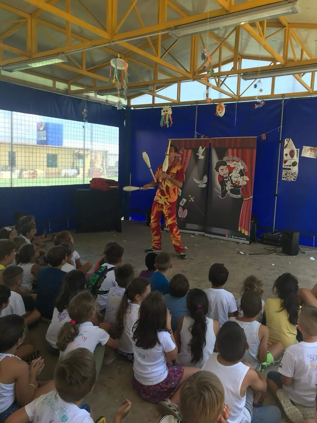 Numero di giocoleria nel cortile della scuola davanti agli alunni seduti