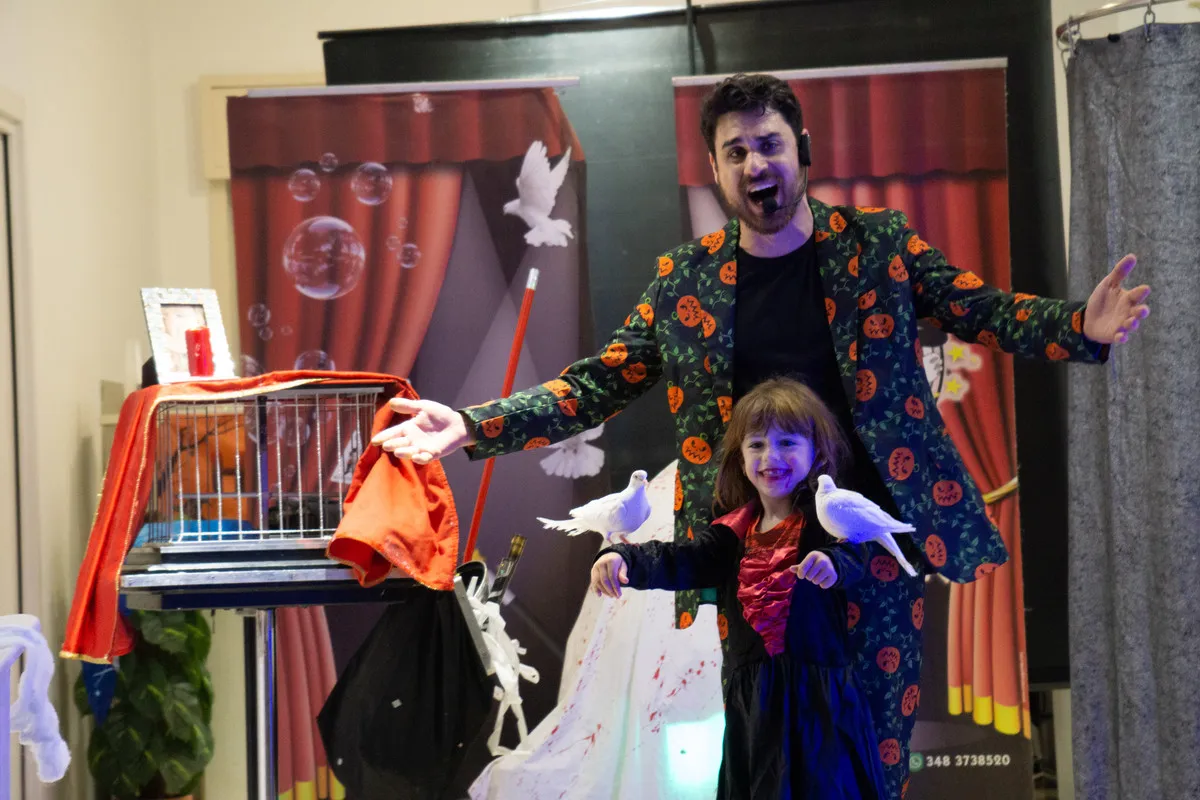 Colombe bianche sul palco insieme alla bambina assistente del mago