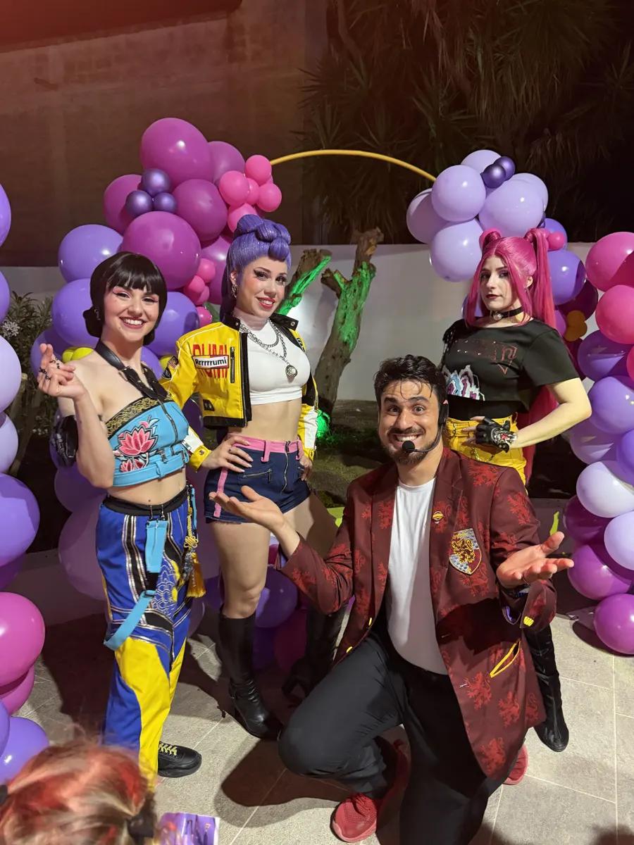 Le tre performer Huntrix in costume con Il Mago Max
