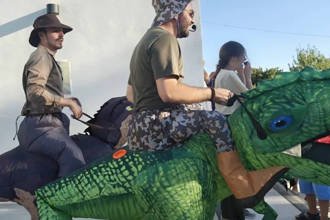 Animatori con costumi gonfiabili da dinosauro verde T-Rex a evento bambini