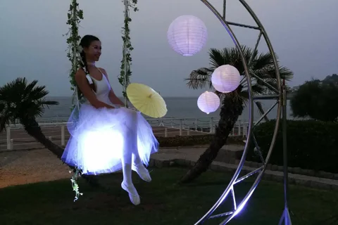 Animatrice in tutù luminoso su altalena luna gigante a matrimonio Sicilia