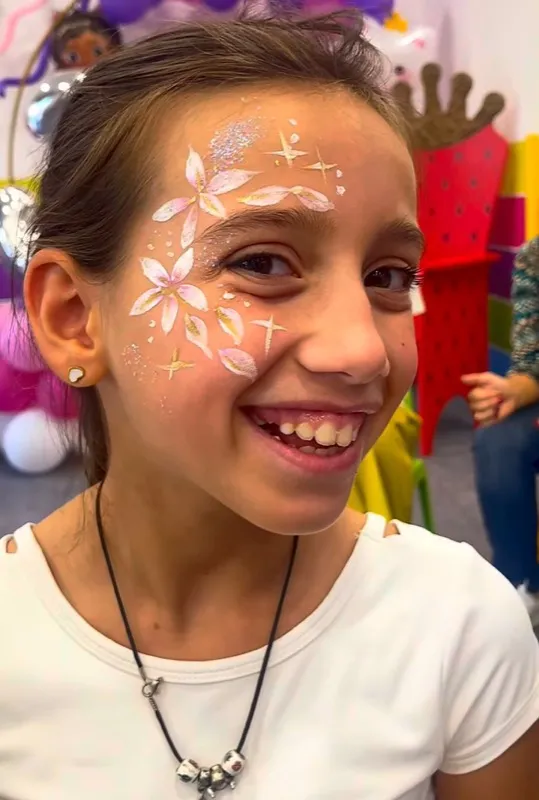 Bambina con truccabimbi a fiori sul viso durante una festa del Mago Max