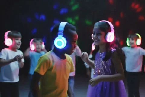 Bambini ballano con cuffie luminose a silent disco