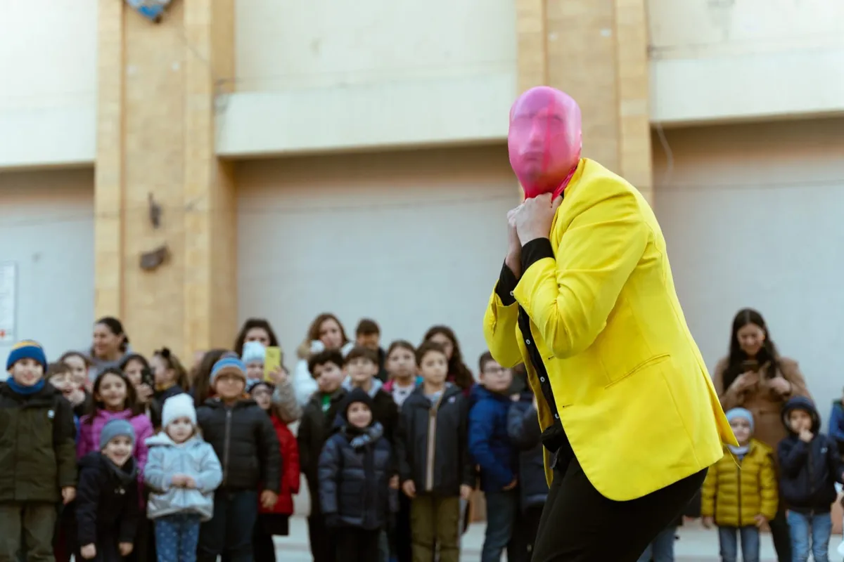 Bambini che ridono tra il pubblico dello spettacolo di clownerie in piazza